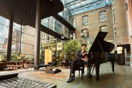 The Set Hotels Revenue Growth (image of girl at piano in Conservatorium Hotel)
