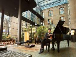 The Set Hotels Revenue Growth (image of girl at piano in Conservatorium Hotel)