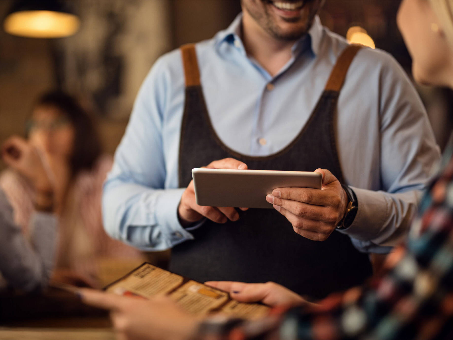 Close-up of waiter taking an order using a tablet