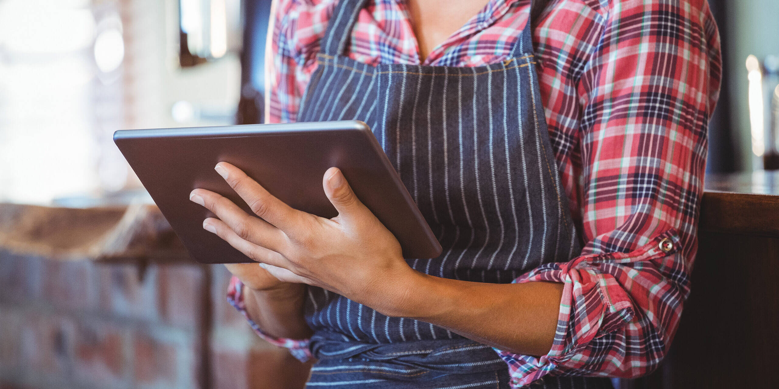 Restaurant employee accessing a restaurant pos system on her tablet device