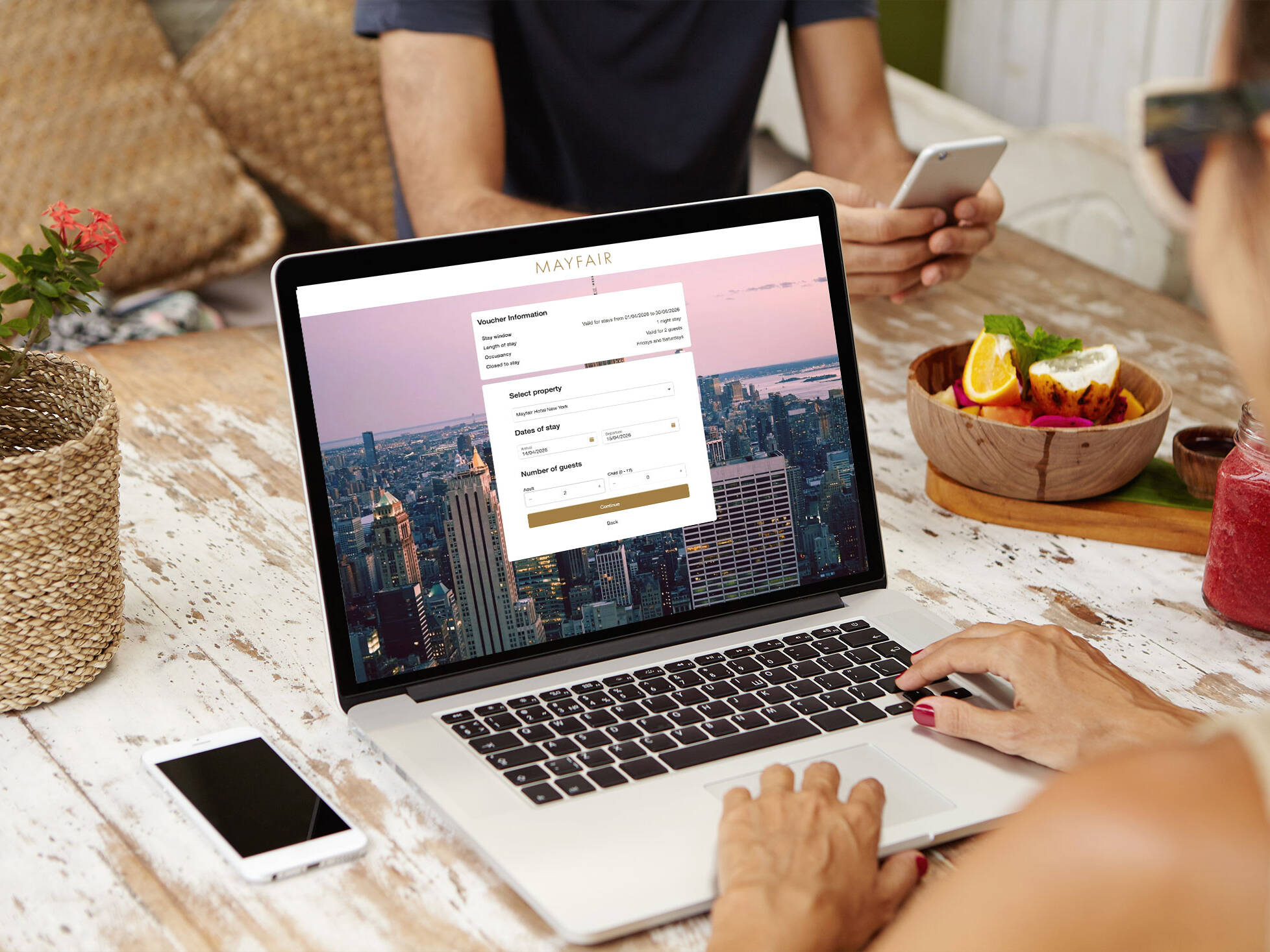 Person using a laptop to complete an online booking through the VoucherCart Reservations Module (VRM), with a hotel reservation and voucher redemption interface.