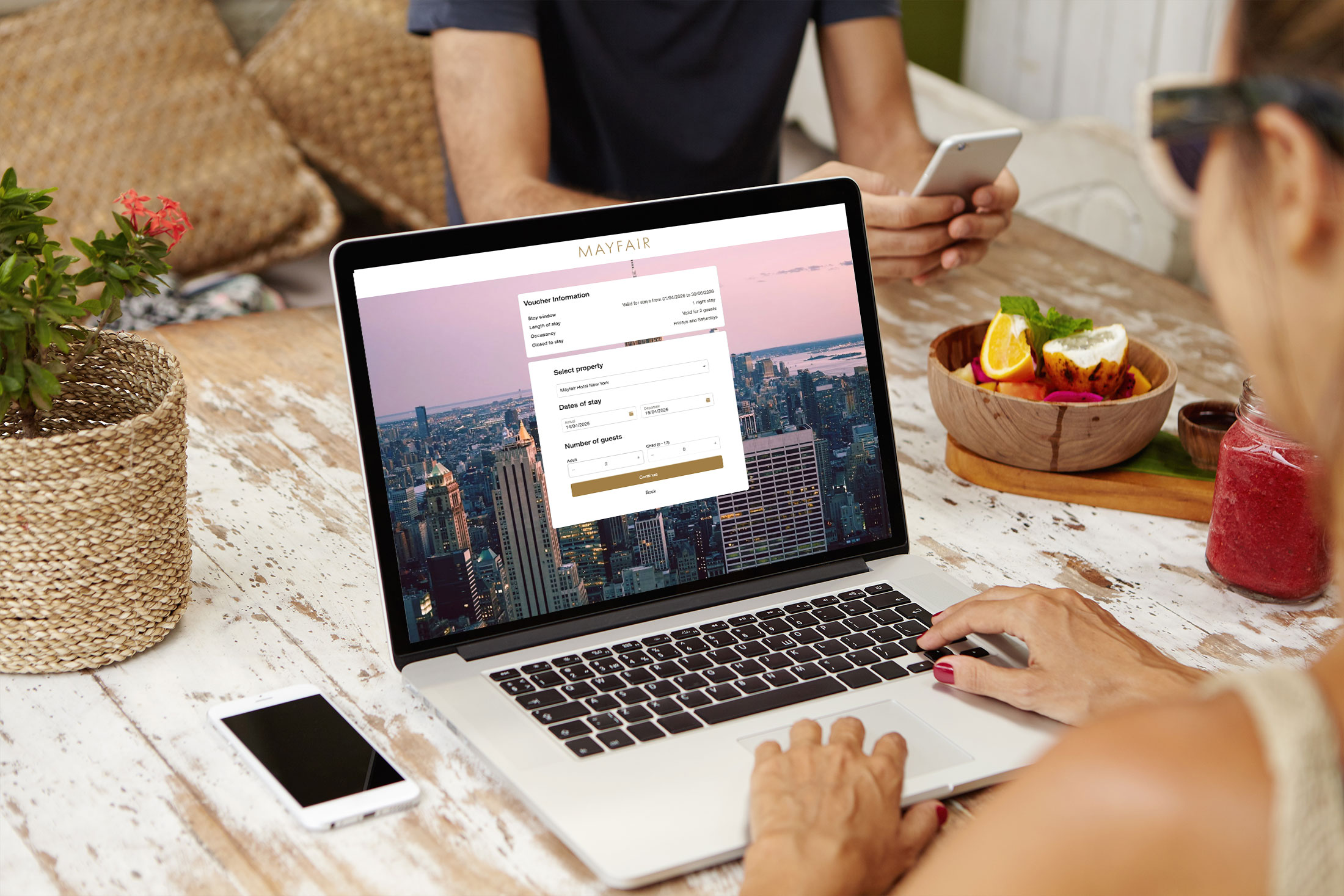 Person using a laptop to complete an online booking through the VoucherCart Reservations Module (VRM), with a hotel reservation and voucher redemption interface.